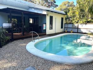 ein Swimmingpool vor einem Haus in der Unterkunft Beachcomber - Rainbow Shores in Rainbow Beach