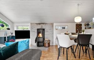 a living room with a fireplace and a table at 3 Bedroom Awesome Home In Bjert in Binderup Strand