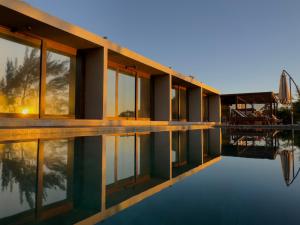 a house with a swimming pool in front of it at Lagoon Suites e Gastronomia in Laguna