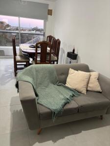 a couch with a blanket on top of it in a living room at Mirador 360 in Villa María +8 photos