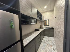 a kitchen with black and white cabinets and a counter at Bisola Residences in Cotonou