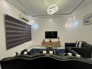 a living room with a couch and a flat screen tv at Bisola Residences in Cotonou