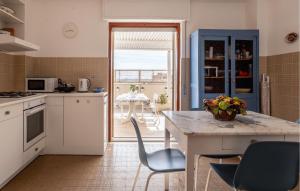 eine Küche mit einem Tisch und Stühlen sowie eine Küche mit Aussicht in der Unterkunft Amazing Apartment In Pozzallo With Wifi in Pozzallo