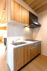 a kitchen with wooden cabinets and a sink at Trailer Ship Garden Aso - Vacation STAY 96758v in Aso