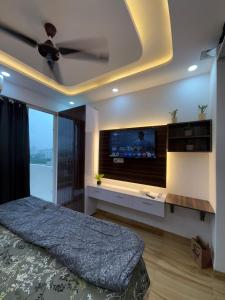 Schlafzimmer mit einem Flachbild-TV und einem Bett in der Unterkunft Kanha stay in Greater Noida