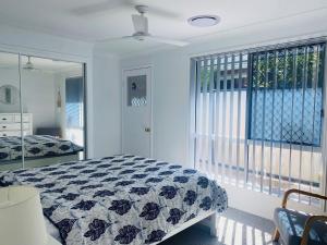 レインボー・ビーチにある29 Satinwood Drive - Rainbow Shores. Pets. Pool. Wifiのベッドと窓のある寝室 +10枚の写真