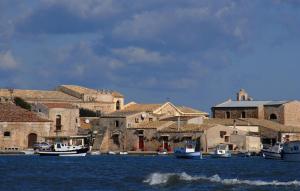 a group of boats in the water in front of buildings at Cozy Apartment In Marzamemi With Wifi in Marzamemi +34 photos