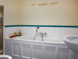 een badkamer met een ligbad en een wastafel bij Ocean Breezes in St Ives