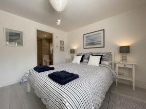 - une chambre avec un grand lit et des serviettes bleues dans l'établissement Well Cottages, à Portmahomack