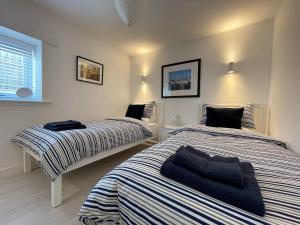 une chambre avec deux lits et une fenêtre dans l'établissement Well Cottages, à Portmahomack