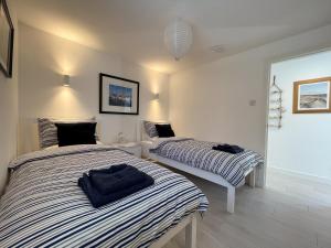 - 2 lits dans une chambre blanche avec jupes dans l'établissement Well Cottages, à Portmahomack 8 autres photos