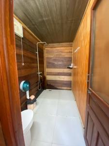 a small bathroom with a toilet and a wooden wall at Ozfarm-kiteBoarding School in Ninh Hải +128 photos