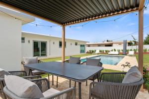 a patio with a table and chairs and a pool at Villa Serena Luxury Home with Private Pool- close to BQN in Maleza