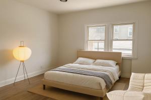 a white bedroom with a bed and a window at Scandinavian Style 1 Bd 15 min to nyc parking in Guttenberg