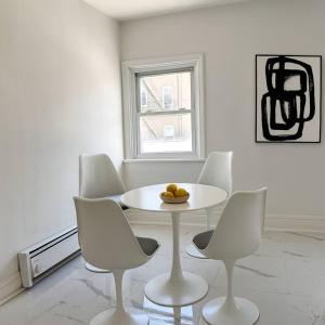 a white dining room with a white table and chairs at Scandinavian Style 1 Bd 15 min to nyc parking in Guttenberg