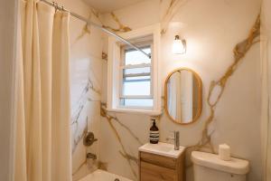 a bathroom with a sink toilet and a window at Scandinavian Style 1 Bd 15 min to nyc parking in Guttenberg