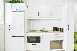 Una cocina con gabinetes blancos y un fregadero. en Reefside at 201 Lake Street, en Cairns