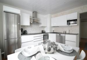 a kitchen with white cabinets and a pot on a table at Central and Spacious Apartment for 4 with Sauna in Kouvola +5 photos