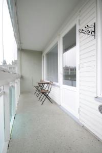 a balcony with chairs and a table on a house at Central and Spacious Apartment for 4 with Sauna in Kouvola