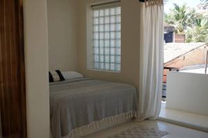 a bedroom with a bed in front of a window at Nicho Suite @ Sayulita Surfside Suites in Sayulita