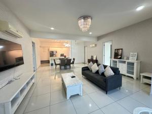 un ampio soggiorno con un divano e un tavolo di Deluxe Seaview Suite Tripe Bed with bath tub 13A a Tanjong Tokong