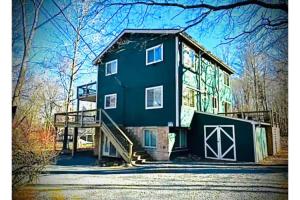 a large house with a staircase in front of it at Sweet Darlene with Hot Tub, Game Room and Pet Friendly in Towamensing Trails