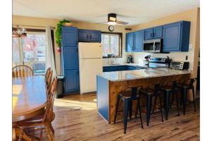 a kitchen with blue cabinets and a table with chairs at Sweet Darlene with Hot Tub, Game Room and Pet Friendly in Towamensing Trails