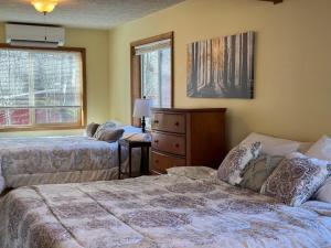 a bedroom with two beds and a dresser and a window at Sweet Darlene with Hot Tub, Game Room and Pet Friendly in Towamensing Trails