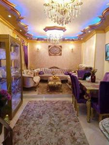 sala de estar amplia con sofá y lámpara de araña. en شقق المحبة, en Taif