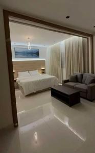 Un dormitorio con una cama, un sofá y un espejo. en شقق المحبة, en Taif
