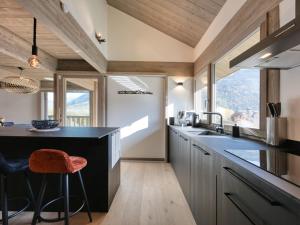 圣热尔韦莱班Chalet moderne à Saint-Gervais, 10 pers, sauna, proche pistes, parking, wifi - FR-1-663-46的厨房配有黑色柜台和一些窗户。