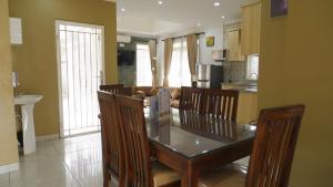 a dining room and kitchen with a glass table and chairs at Diyar Villas Puncak M6/12 in Puncak