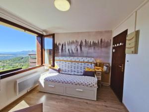 une chambre avec un lit et une grande fenêtre dans l'établissement Studio 2 pers au pied des pistes - Ski et rando - FR-1-393-185, à Chaillol