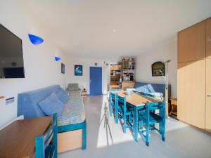 un soggiorno con un divano blu e un tavolo di Studio 6 pers. au Corbier, accès rapide aux pistes - FR-1-267-318 a Villarembert