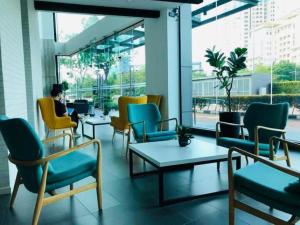 a person sitting in a room with chairs and tables at Deluxe Seaview Suite Tripe Bed with bath tub 13A in Tanjong Tokong