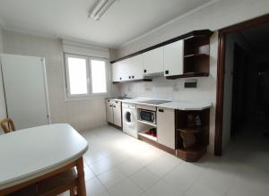a kitchen with a stove and a microwave in it at COSTA VASCA LEIOA - HoME in Leioa