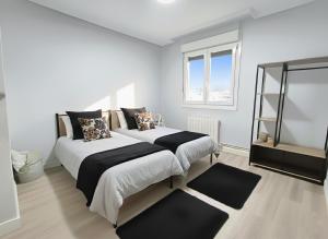 a bedroom with two beds and a window at COSTA VASCA LEIOA - HoME in Leioa +19 photos