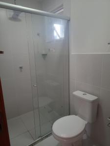 a bathroom with a toilet and a glass shower at Apartamento novo em condomínio in Ananindeua
