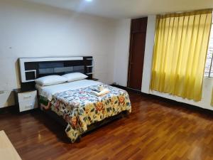 a bedroom with a bed and a wooden floor at Hostal Europa in Arequipa