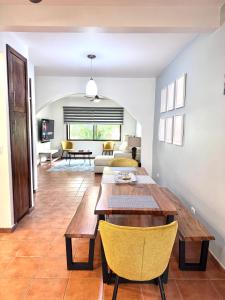 a living room with a wooden table and yellow chairs at Gorgeous Three Bedroom Townhouse in Coco