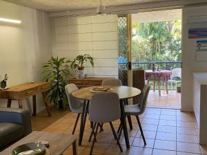 a living room with a table and chairs and a patio at Baden 26 - Rainbow Shores - Swimming pools - Tennis court - Walk to beach in Rainbow Beach