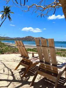 a wooden chair sitting on a beach near the ocean at Gorgeous Three Bedroom Townhouse in Coco