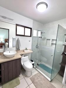 a bathroom with a toilet and a glass shower at Gorgeous Three Bedroom Townhouse in Coco