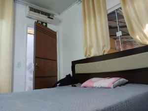 a bedroom with a bed and a window and a door at Pousada vale das aguas in Foz do Iguaçu