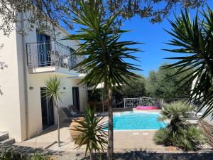 a villa with a swimming pool and palm trees at Nefeli Villas in Hersonissos +68 photos