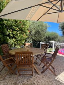 a wooden table and chairs under an umbrella at Nefeli Villas in Hersonissos