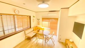 a dining room with a table and chairs and a tv at Family Home Walking to the Beach Park & Playground in Hasunuma
