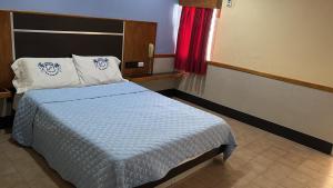 een slaapkamer met een bed met een blauw dekbed bij Hotel Cajigal Caracas in Caracas