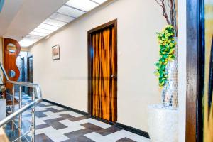 a hallway with a door and a tile floor at Hotel O Circus Avenue Road in Kolkata +29 photos
