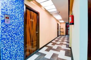 a hallway with blue tiles on the walls and a door at Hotel O Circus Avenue Road in Kolkata